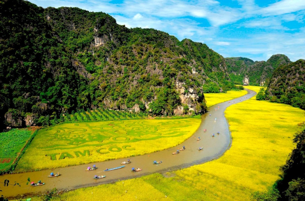 Tam Coc is renowned for its stunning landscapes of towering limestone peaks, lush rice paddies